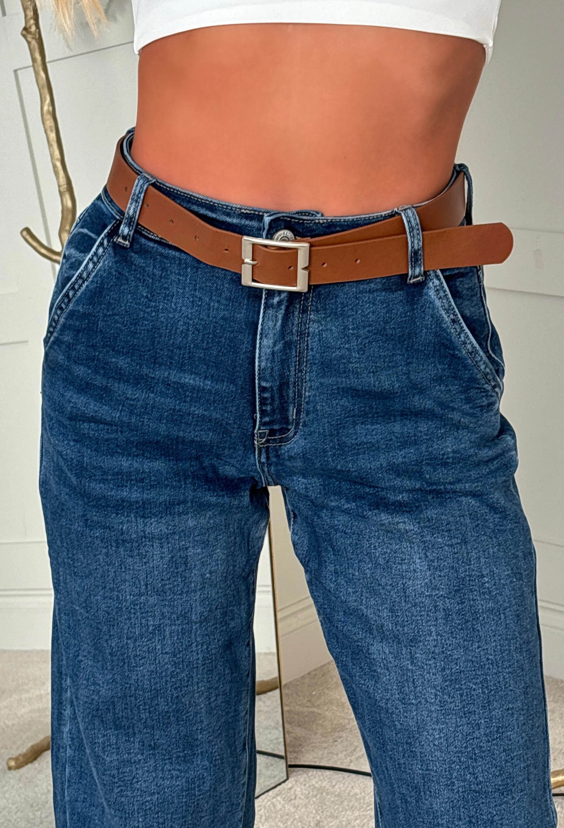 Mid wash stretch denim barrel jeans with a relaxed wide leg, high waist and brown belt.
