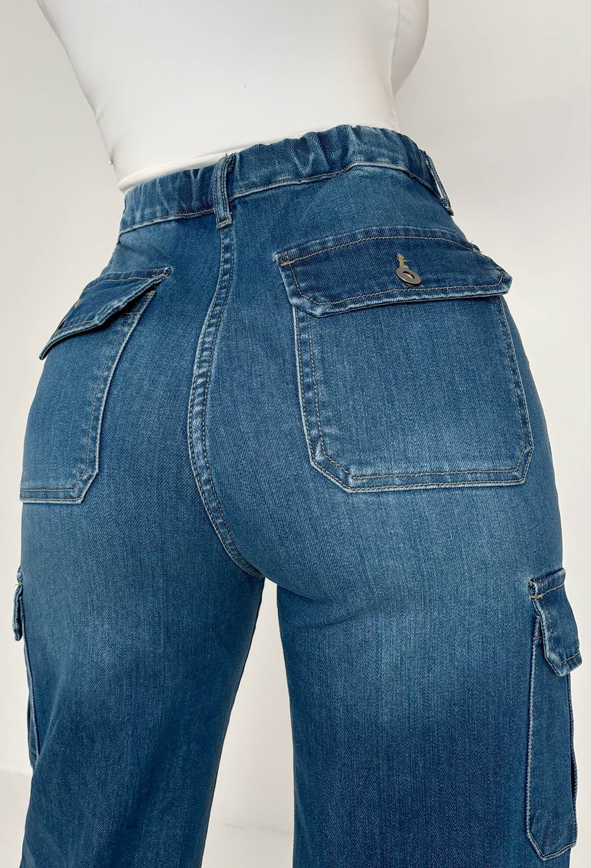 Back view of dark wash cargo denim wide leg jeans with flap pockets, relaxed loose fit and structured denim fabric.