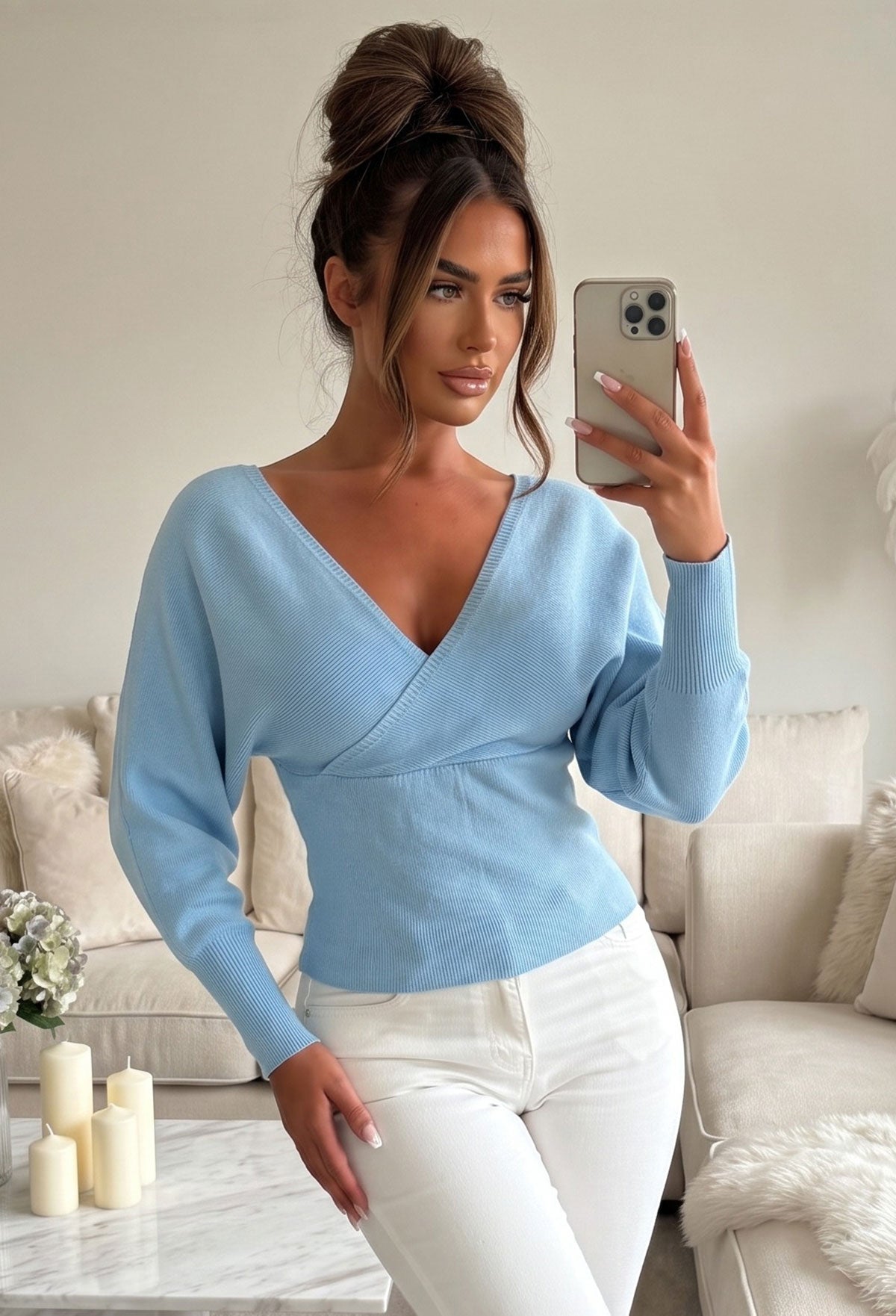 Blue wrap over v neck jumper with long batwing sleeves and a fitted ribbed waist.