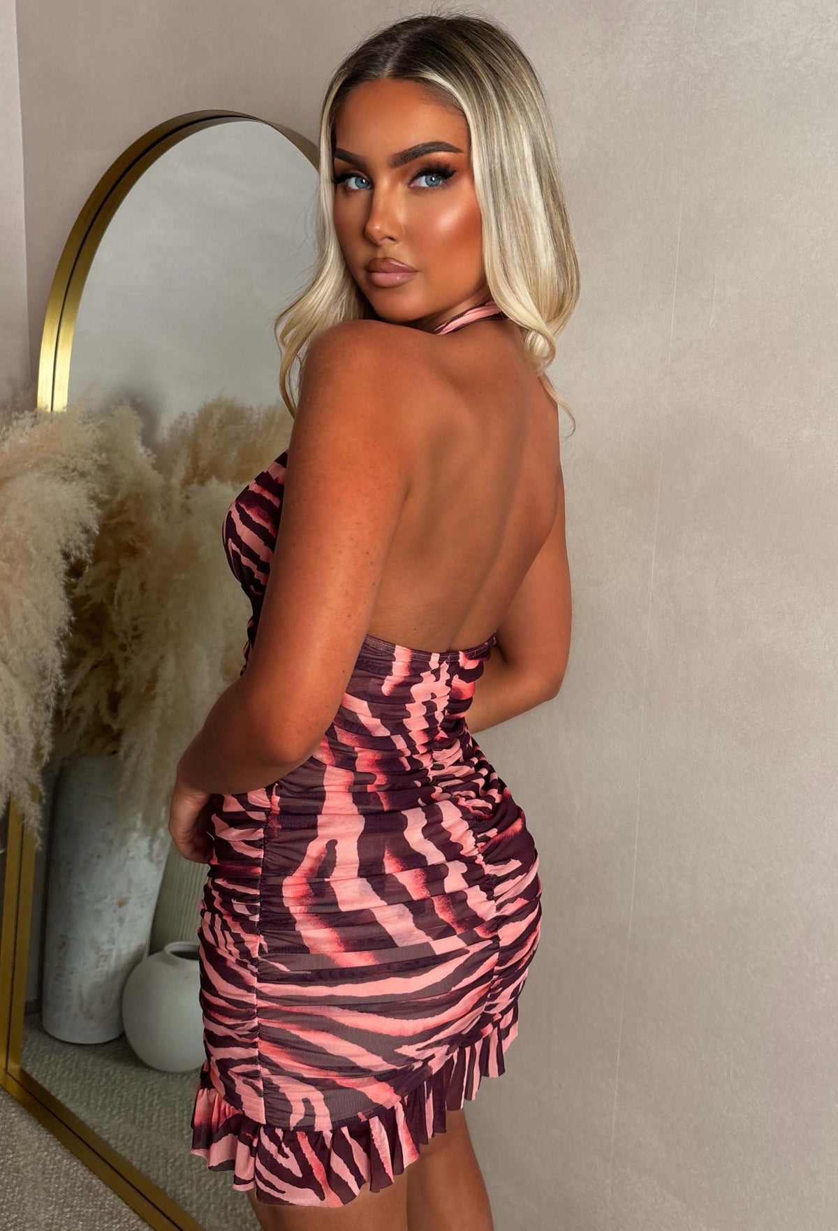 Multi zebra print halter mini dress with a plunging neckline, ruched front and frill hem.