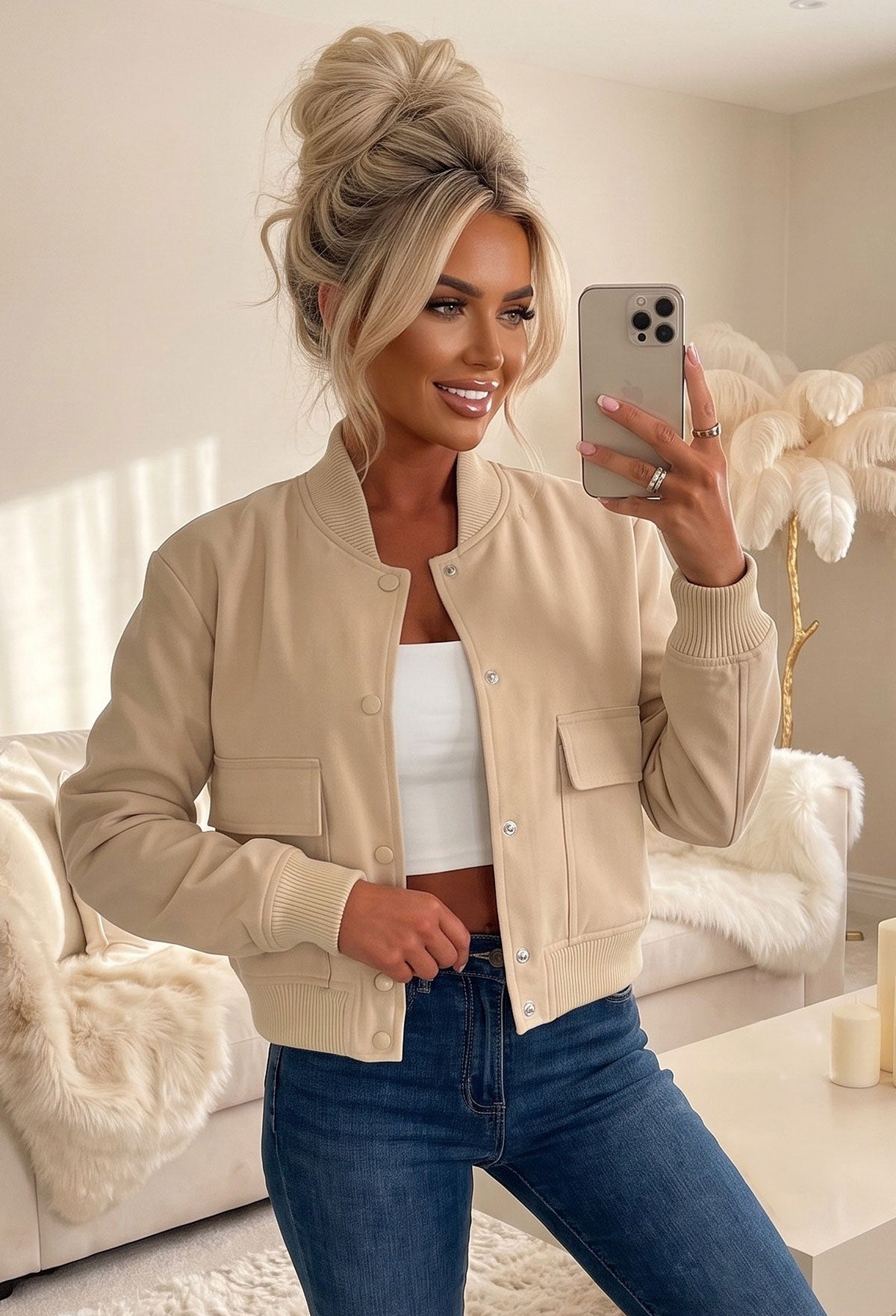 Beige front pocket bomber jacket with silver popper fastening, ribbed cuffs and hem, styled with light blue jeans.