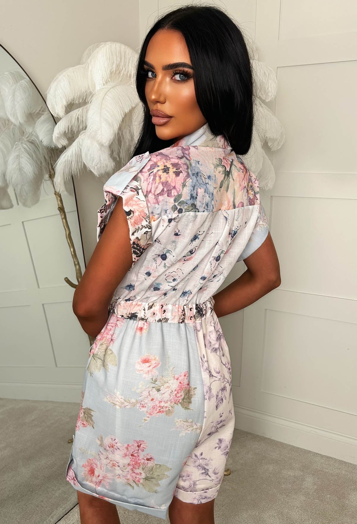 Blue floral short sleeve playsuit with a collared neckline, button front, drawstring waist and relaxed fit.