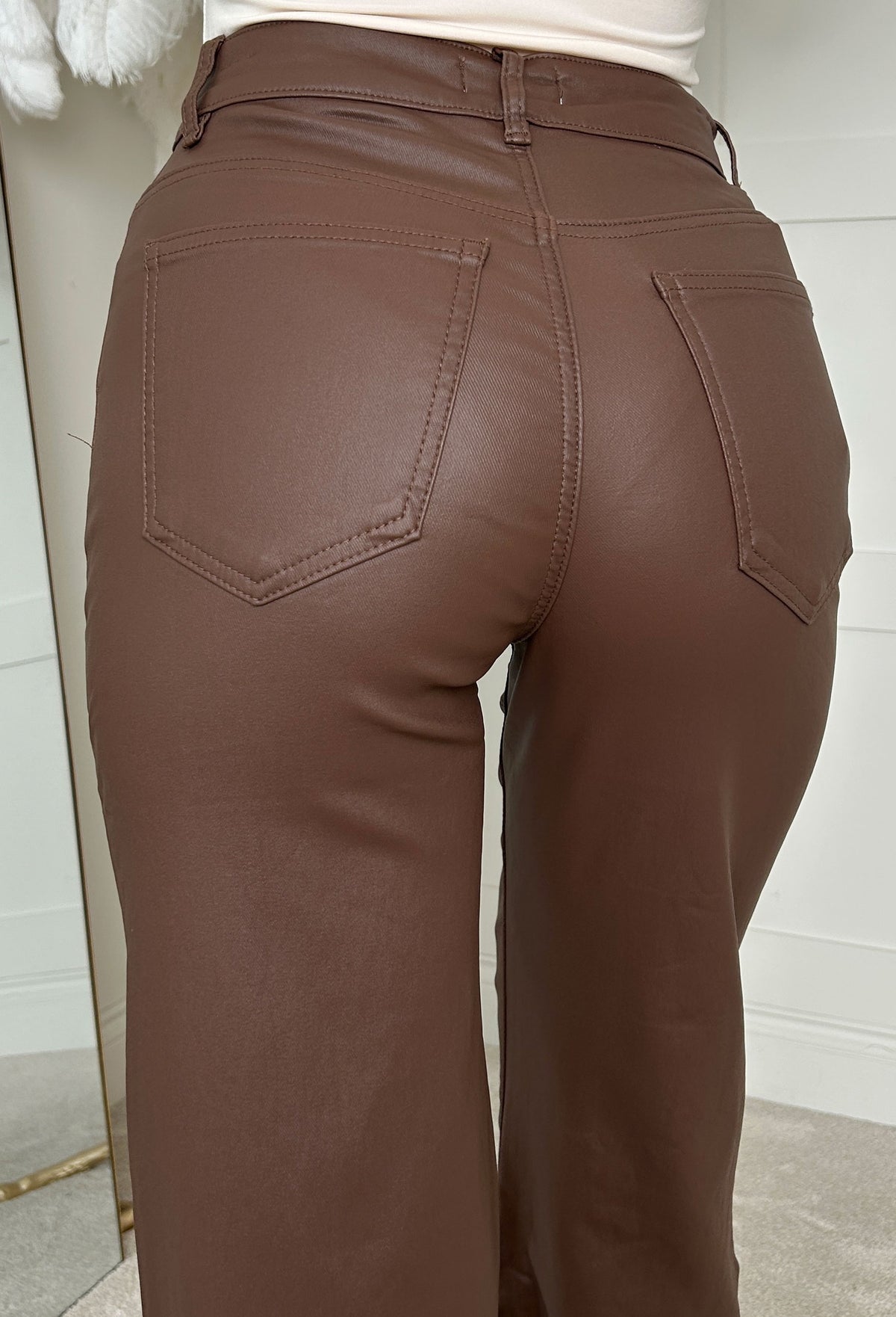 Brown faux leather stretch wide leg jean with high waist, belt loops and a smooth, glossy finish.
