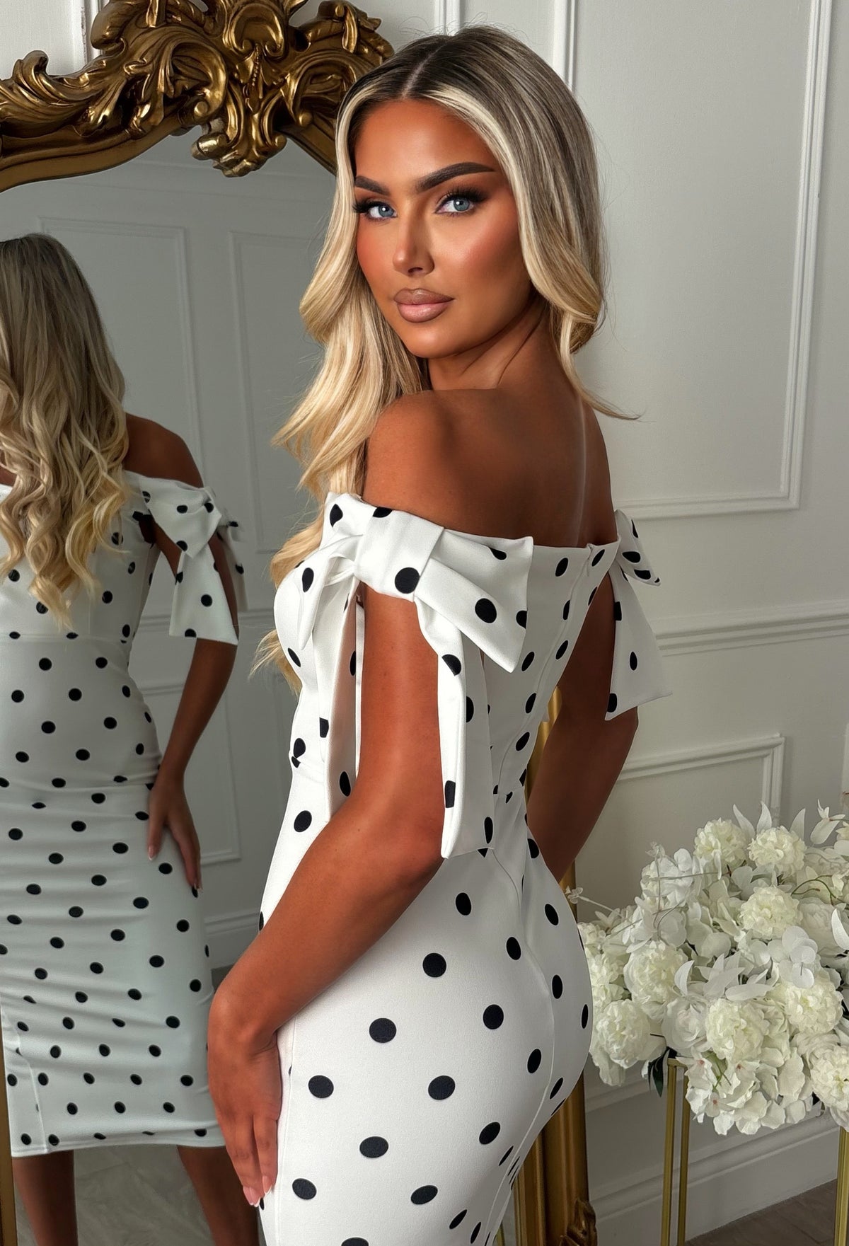 Monochrome polka dot midaxi dress with off-the-shoulder neckline, fitted silhouette and side bow detail.