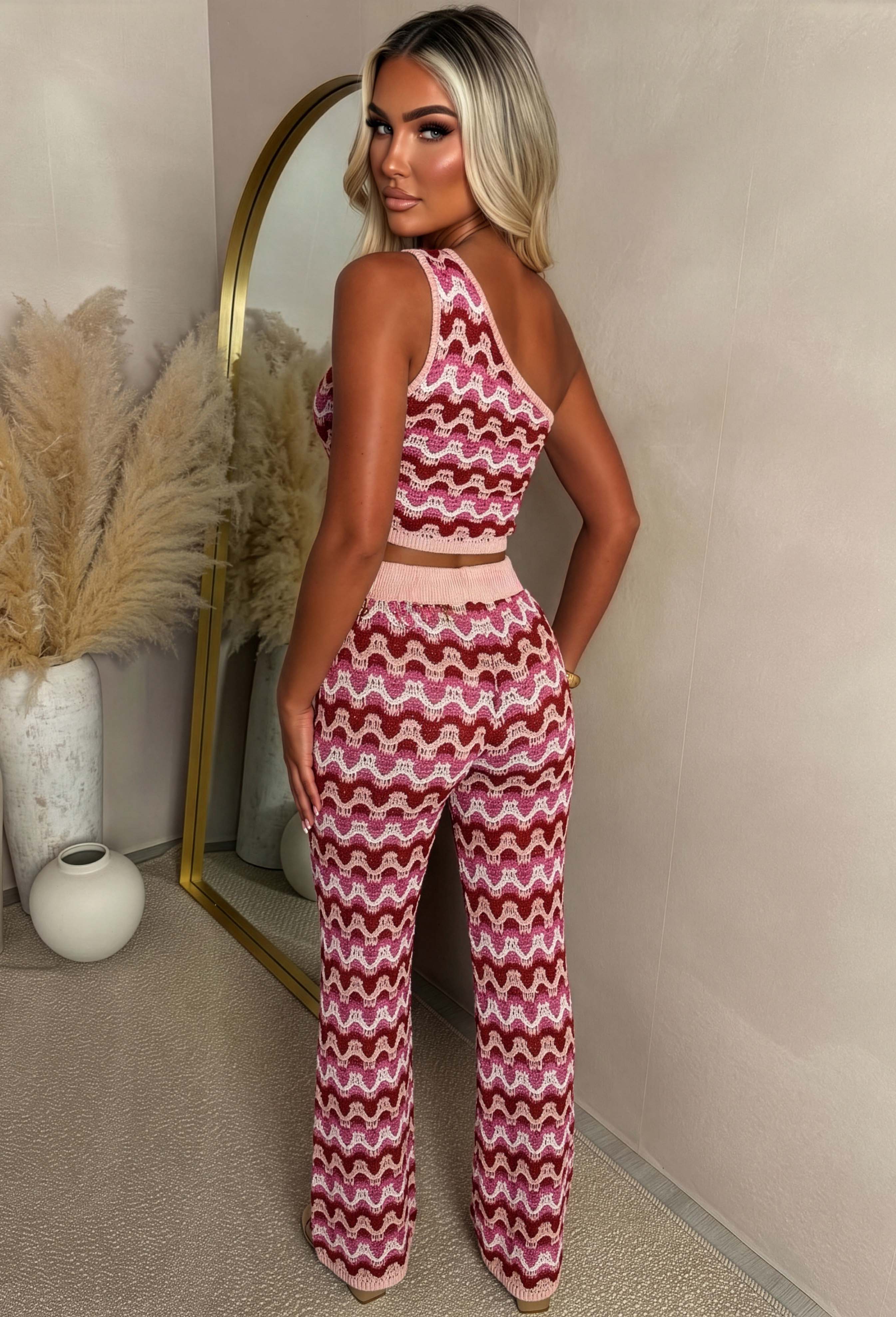 back shot Hot pink knitted trousers with a bold zig zag geometric pattern, fitted silhouette, and stretchy fabric designed for a comfortable, statement-making look.