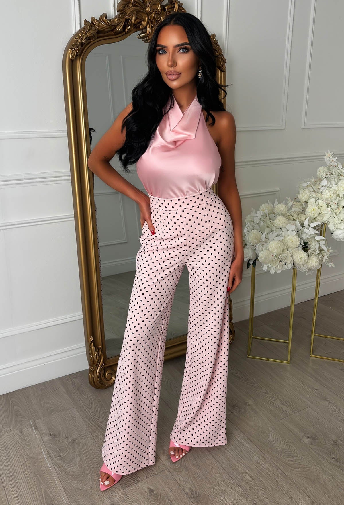Pink polka dot high waisted wide leg trousers with a fitted waist and flowing full-length legs.