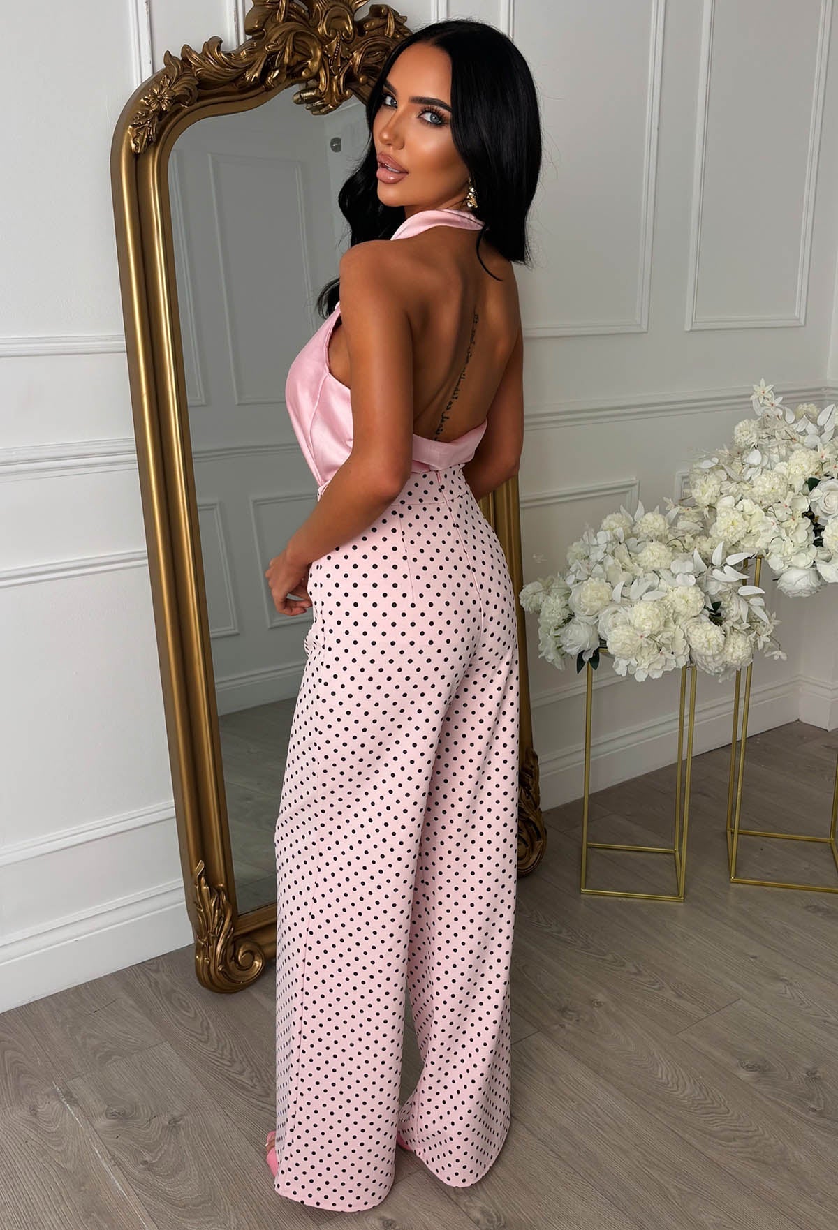 Pink polka dot high waisted wide leg trousers with a fitted waist and flowing full-length legs.