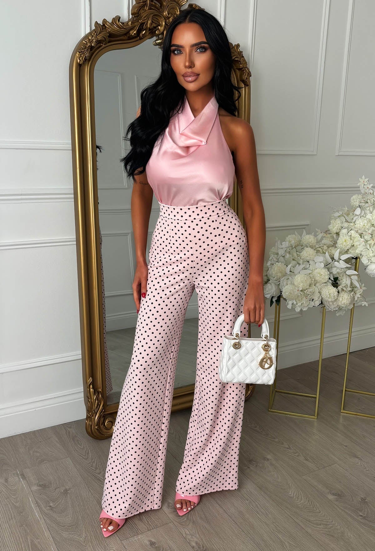 Pink polka dot high waisted wide leg trousers with a fitted waist and flowing full-length legs.