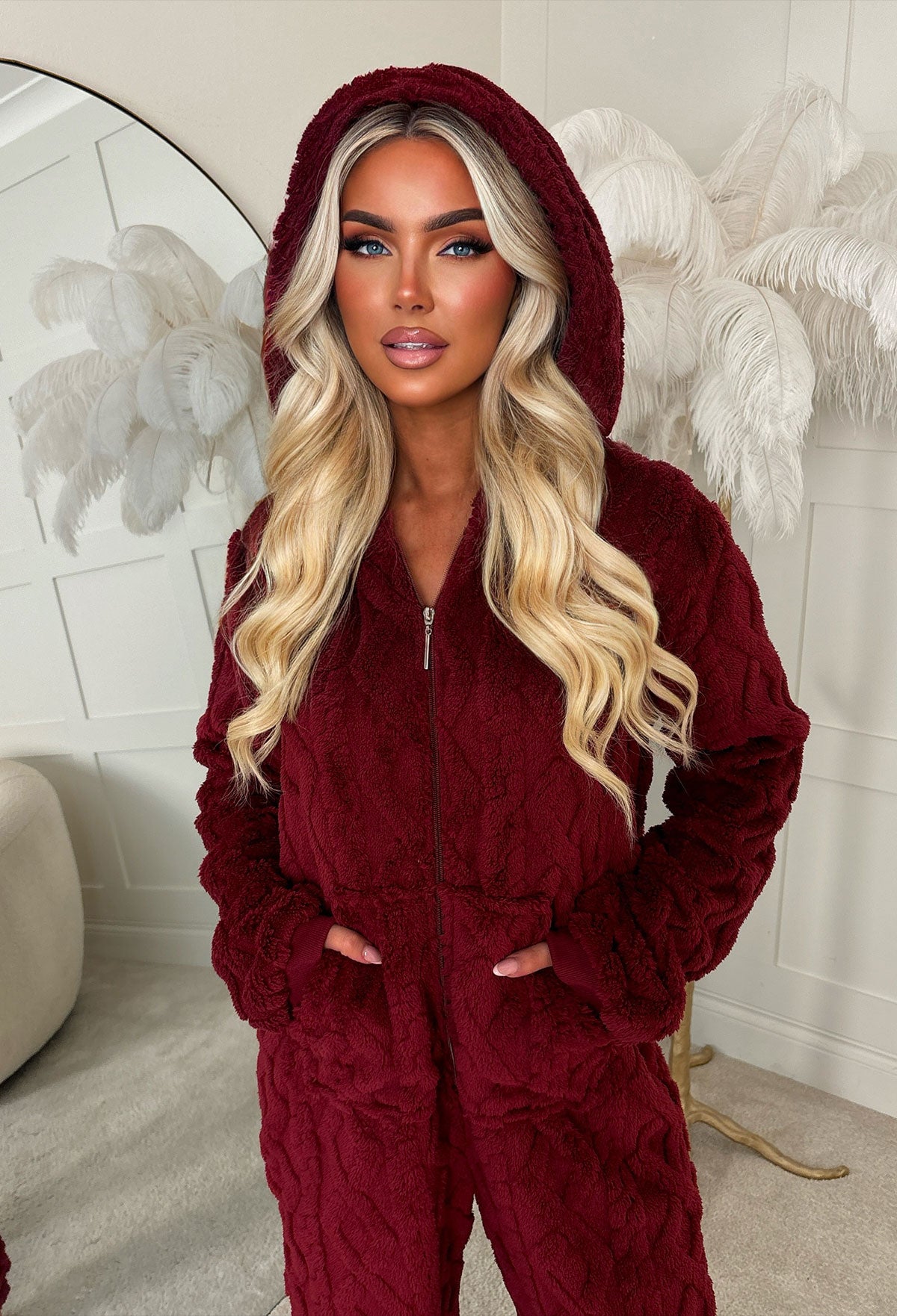 Burgundy cable knit fluffy onesie with long sleeves, cuffed hems and soft textured fabric.