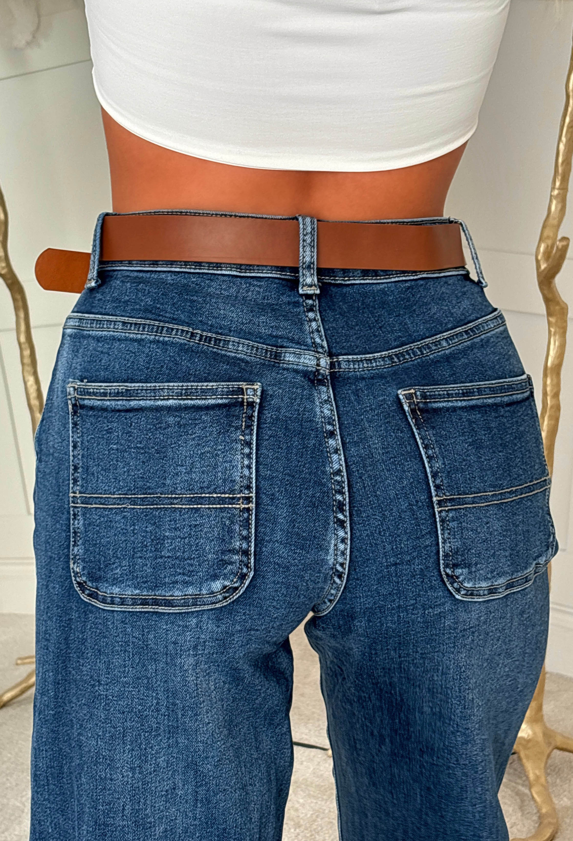Mid wash stretch denim barrel jeans with a relaxed wide leg, high waist and brown belt.