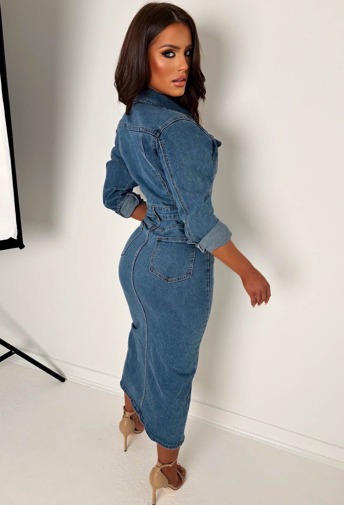 Mid wash stretch denim long sleeve dress with button front, chest pockets and a front split hem.