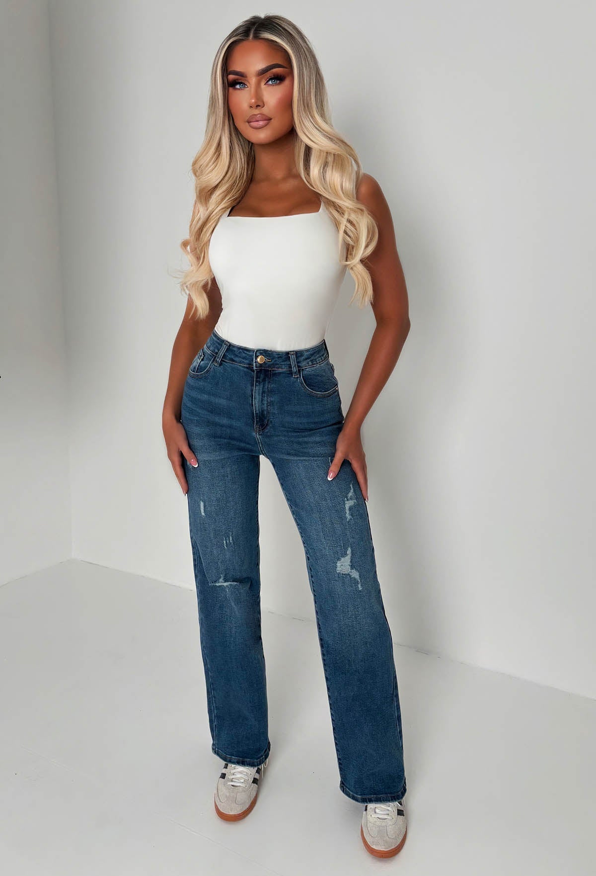 Back view of mid wash straight leg jeans with a high waist, classic five-pocket design and subtle fading.