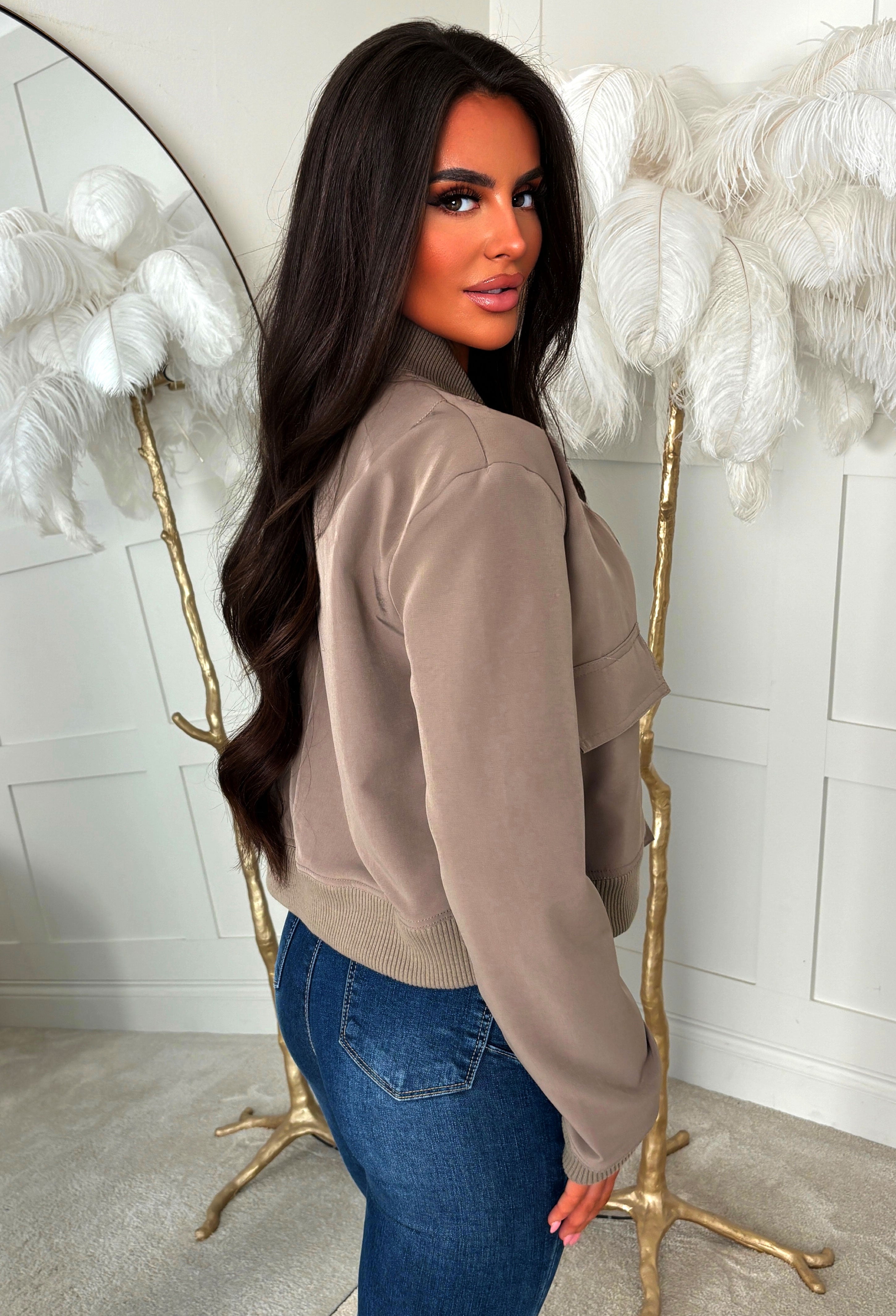 Mocha front pocket bomber jacket with ribbed collar and cuffs, worn open over a white crop top and jeans.