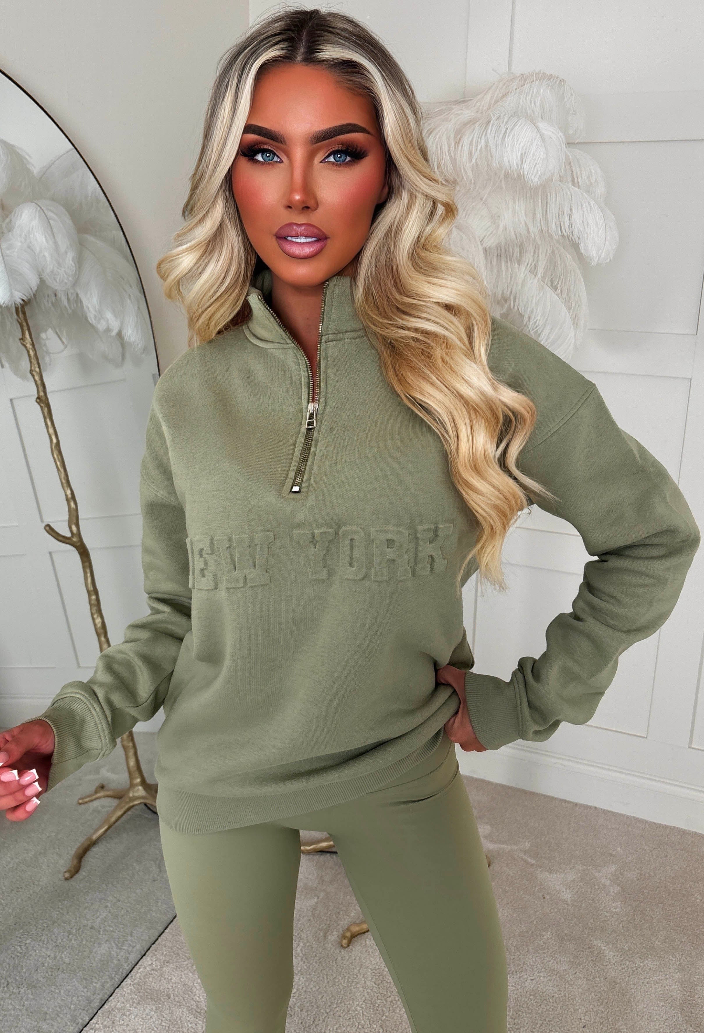 Green half zip sweatshirt with a relaxed fit, ribbed cuffs and hem, and bold New York slogan across the chest.