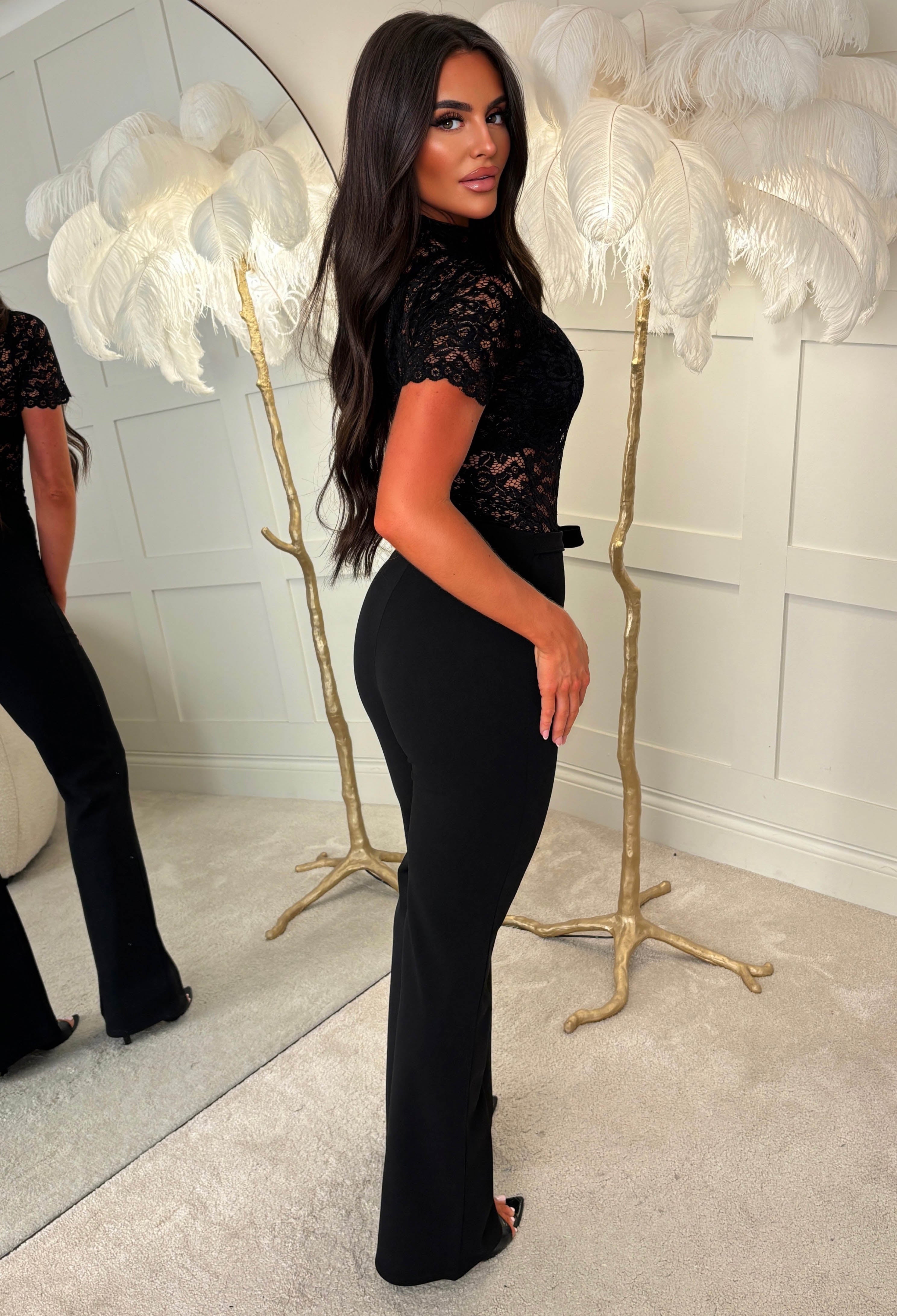 Black lace bodysuit with short sleeves, high neckline and sheer floral lace detailing.