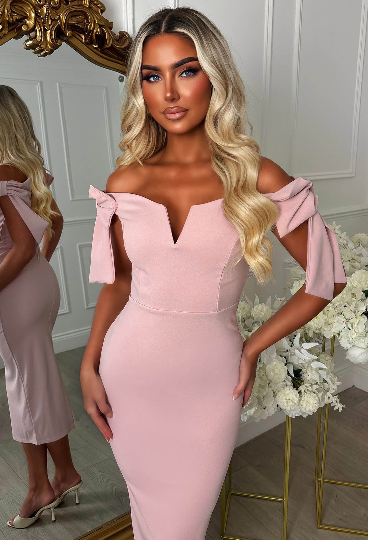 Pink midaxi dress with bardot off-shoulder neckline, fitted silhouette and statement side bow tie detail.
