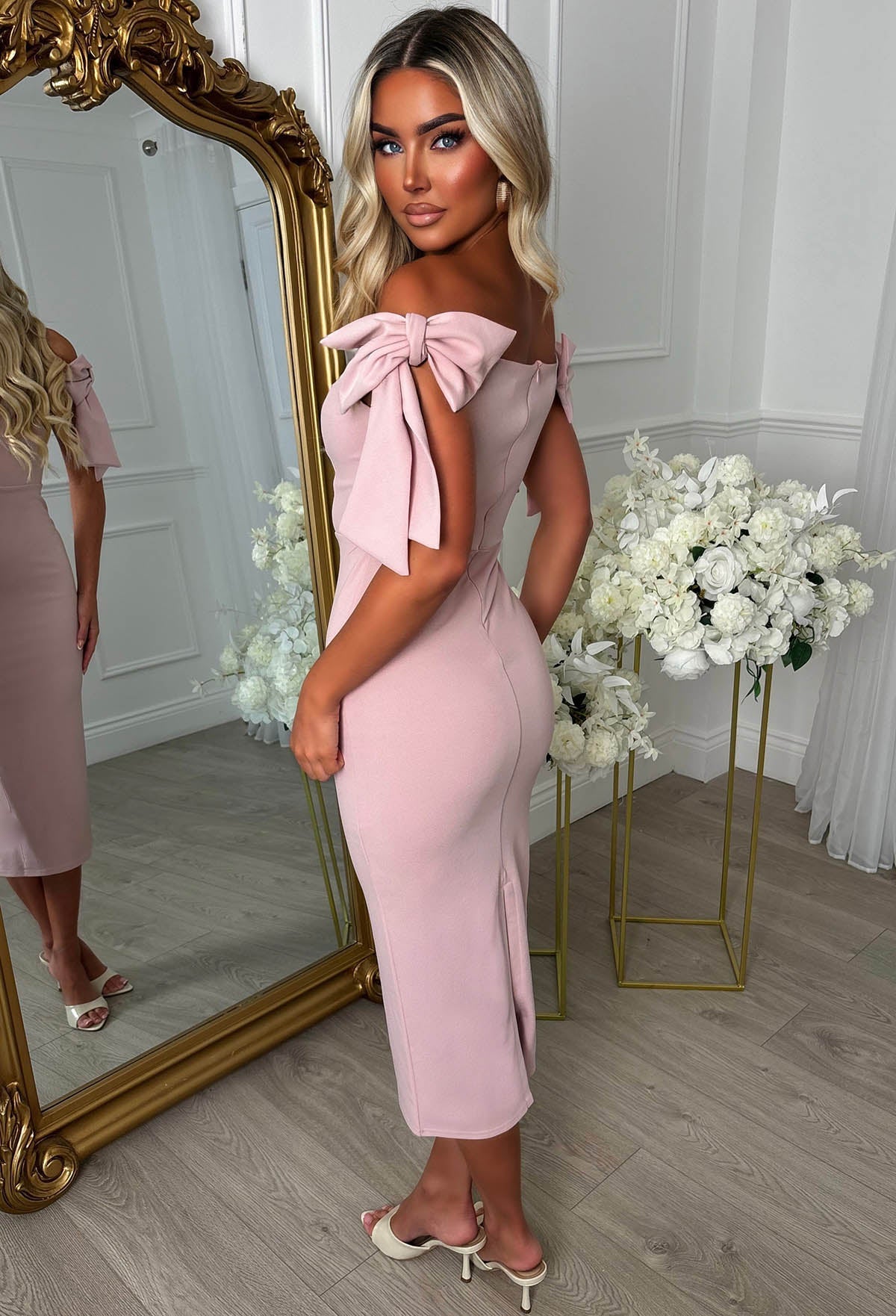 Pink midaxi dress with bardot off-shoulder neckline, fitted silhouette and statement side bow tie detail.