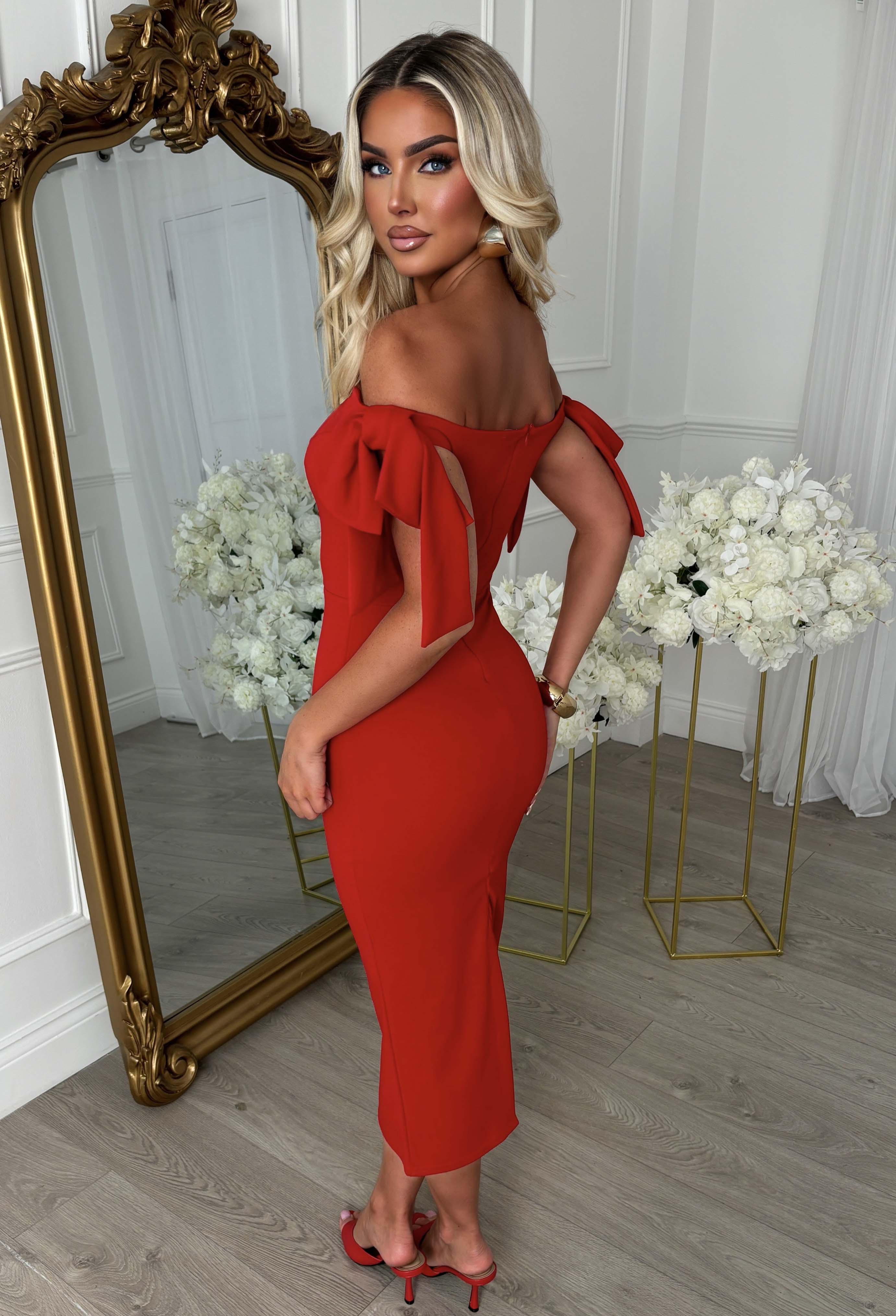 Red maxi dress with off-the-shoulder neckline, fitted silhouette and statement side bow detail.