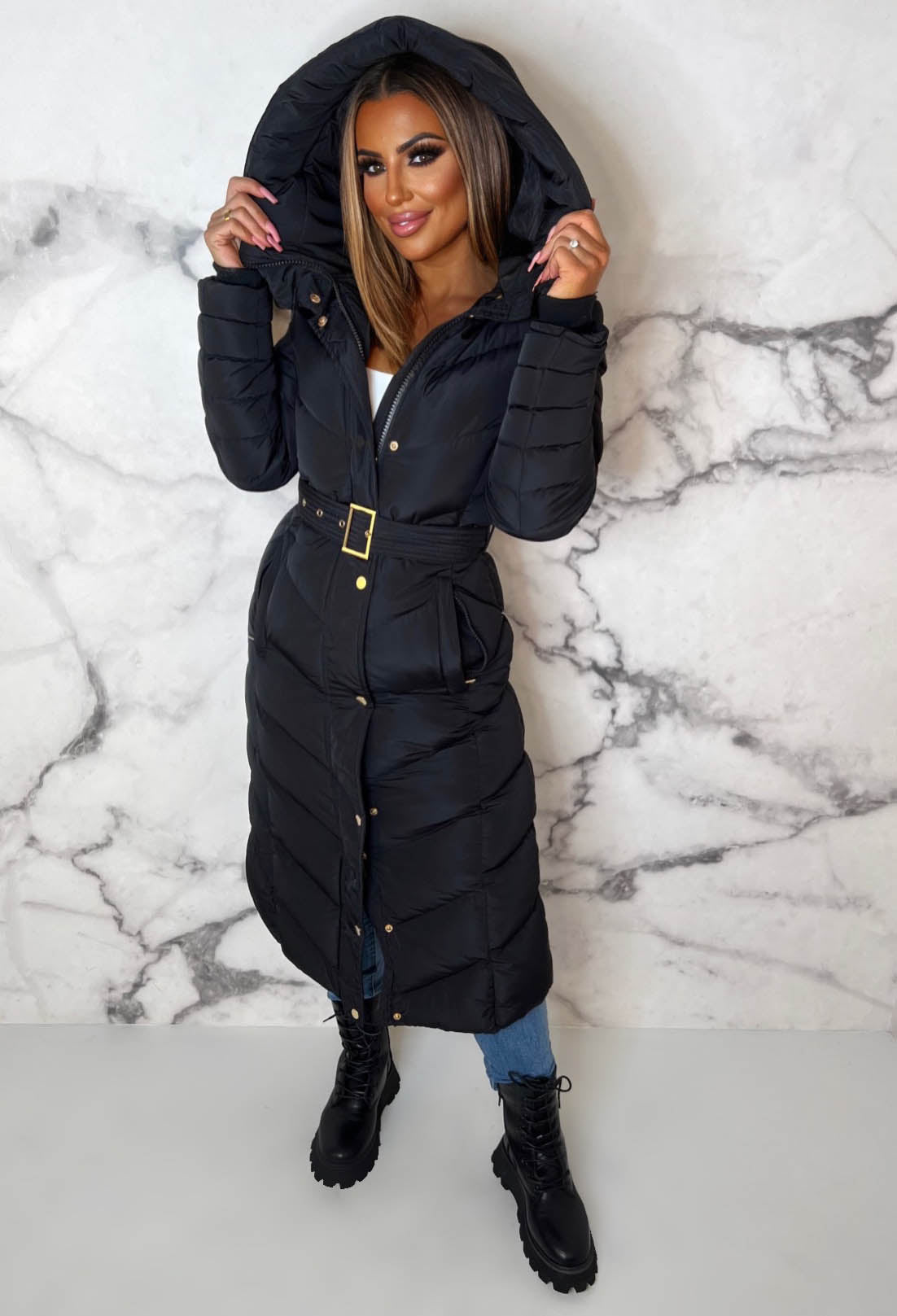 Black chevron belted hooded padded coat with fleece lining, gold hardware and long quilted sleeves.
