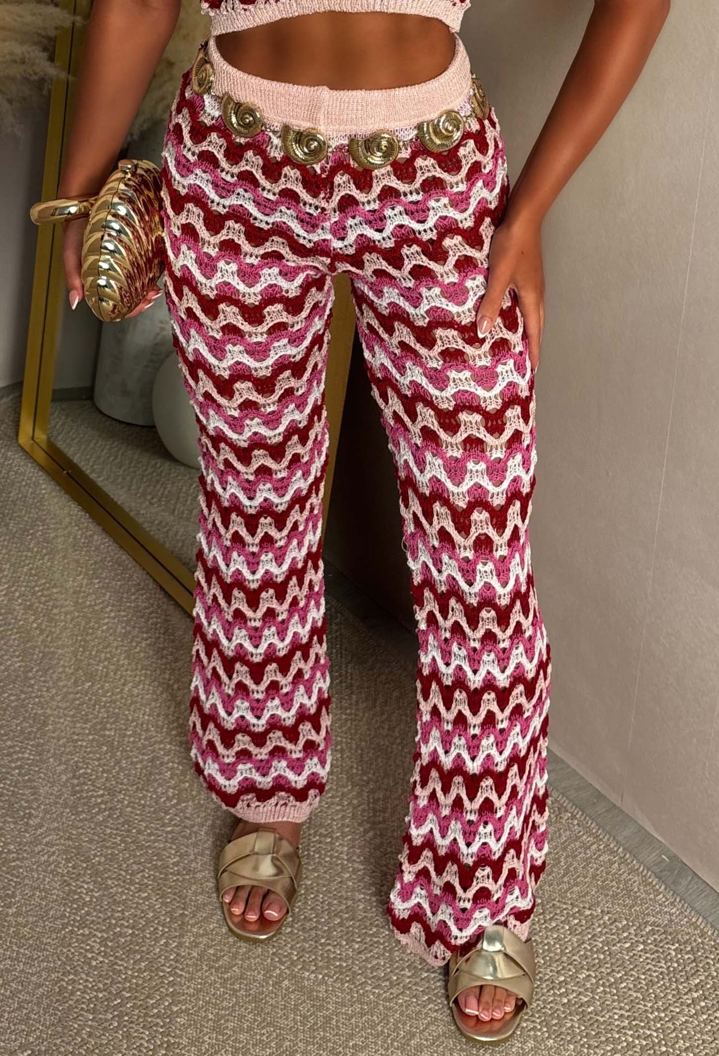 Hot pink knitted  trouser close up shot with a bold zig zag geometric pattern, fitted silhouette, and stretchy fabric designed for a comfortable, statement-making look.