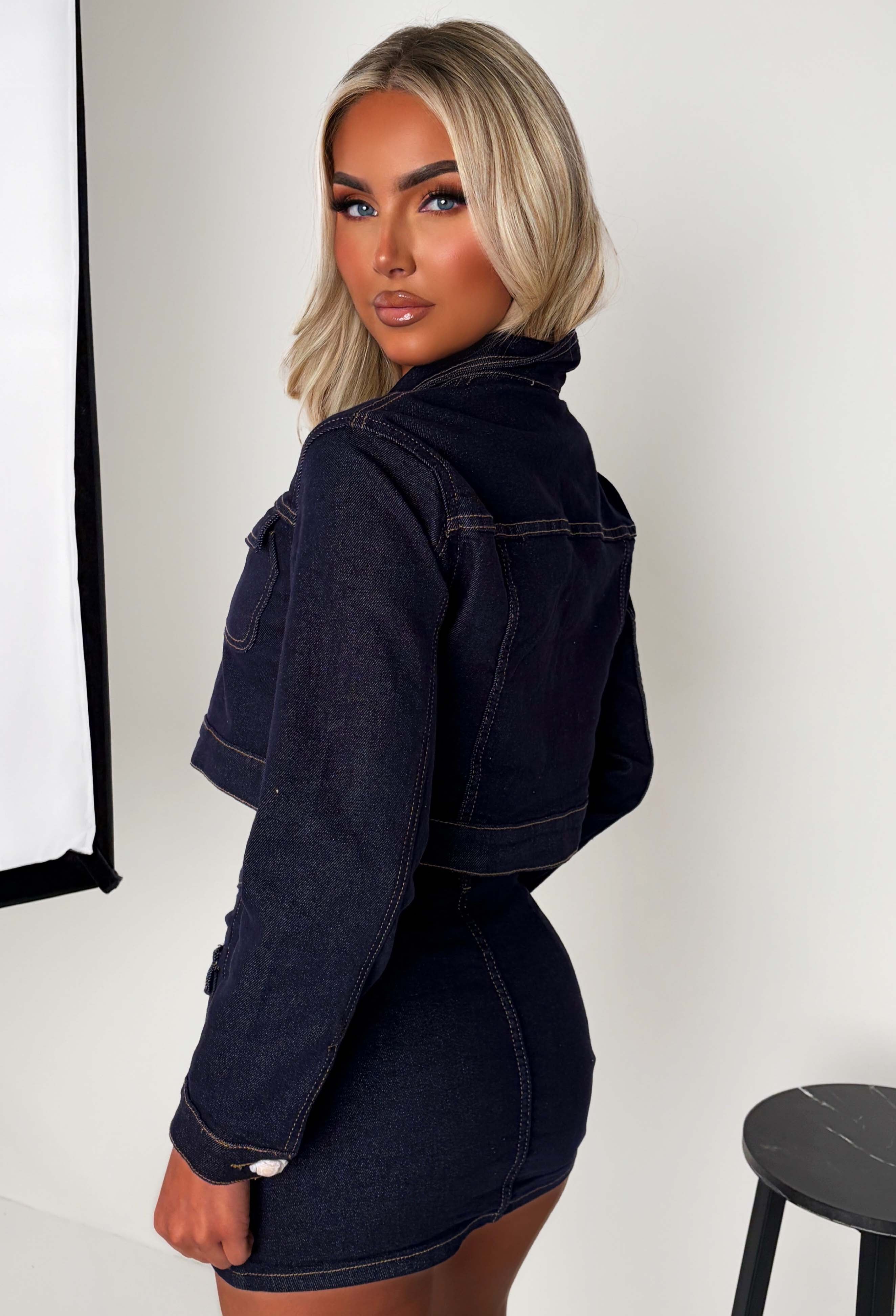 Dark wash denim mini skirt with front button fastening, patch pockets and a fitted silhouette.